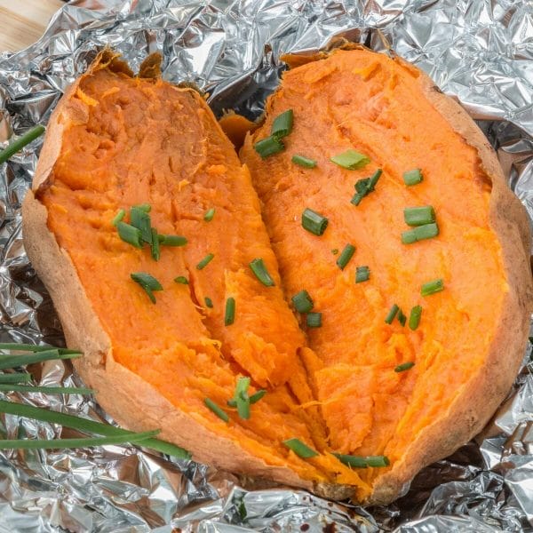 oven baked sweet potato, sliced open and topped with chives