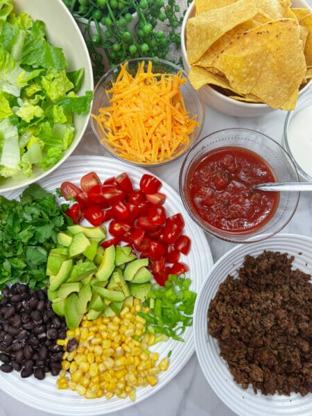 taco salad ingredients on platters for self serve