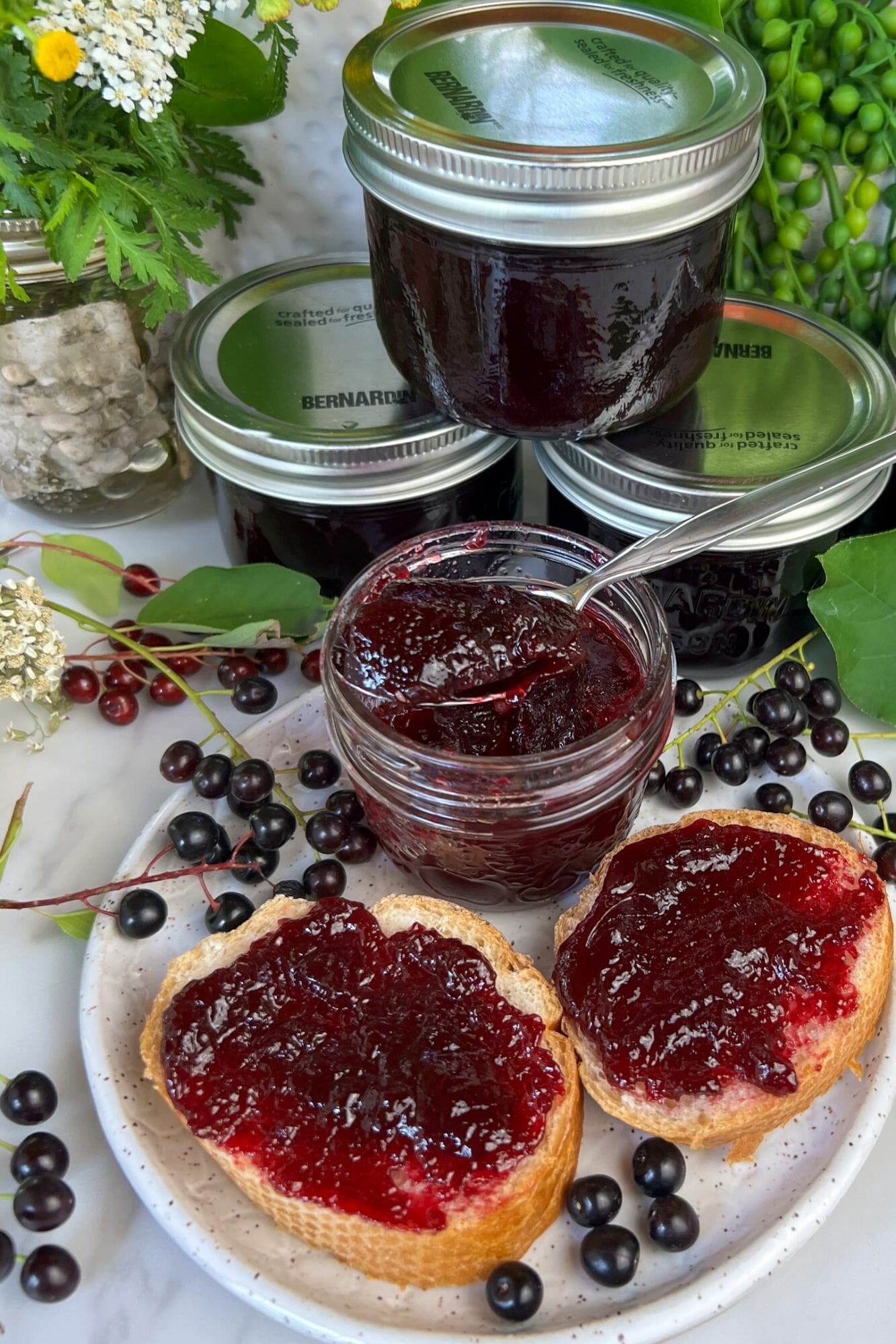 stack of Chokecherry Jelly jars and some spread on toast in the foreground