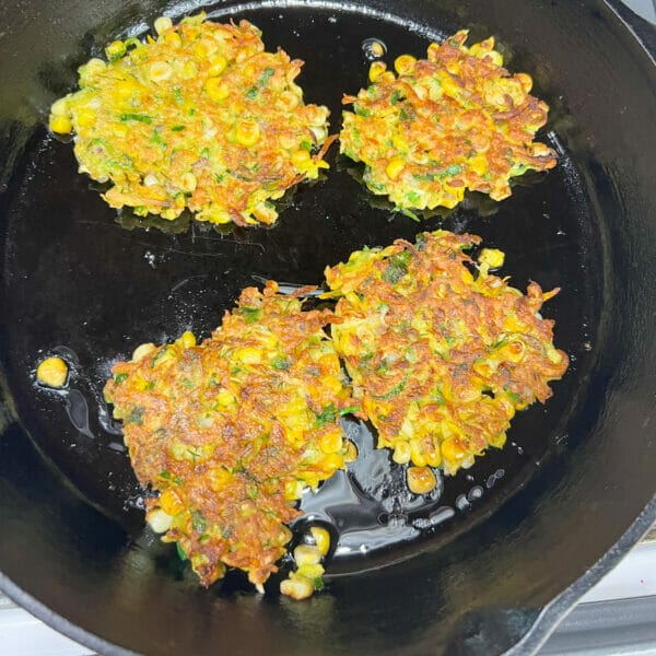 golden brown fritters in hot oil in cast iron pan