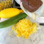 grated yellow zucchini in pile on wax paper with 1 cup written in sharpie