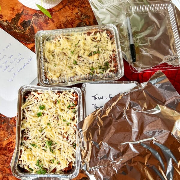 foil trays with baked spaghetti and cheese with instructions ready for freezing