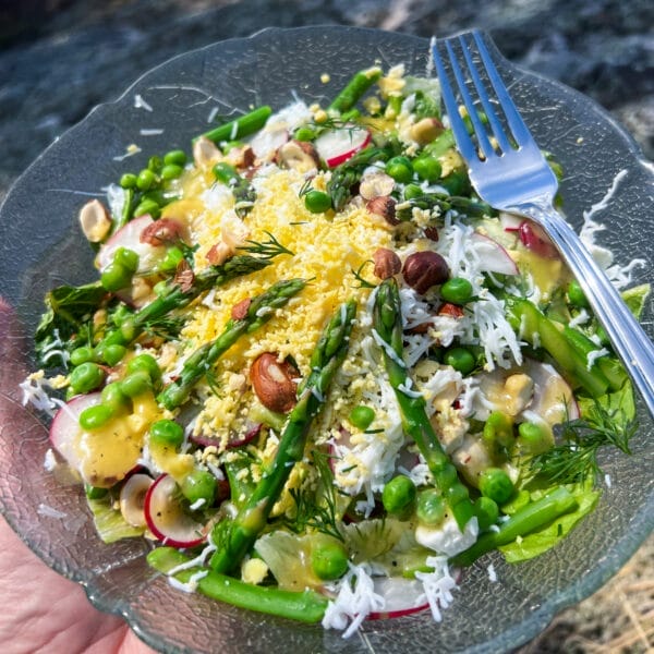 asparagus salad on glass plate with shredded egg and fork
