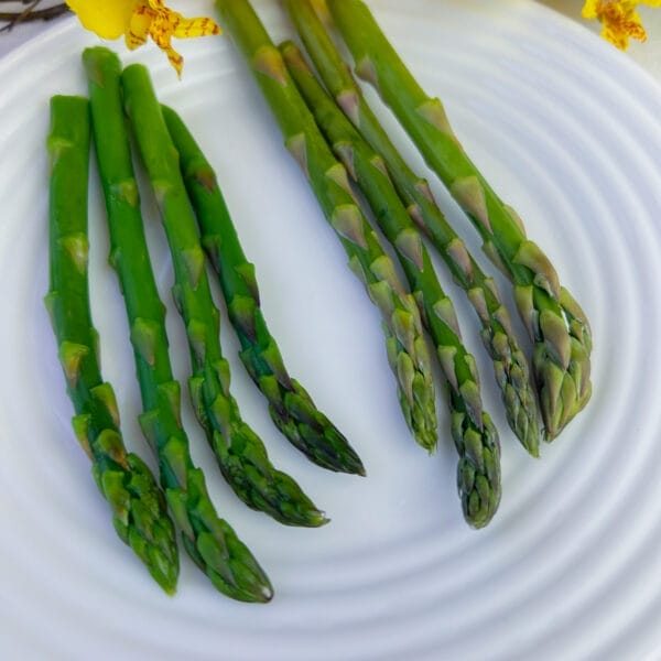 four spears blanched asparagus four spears raw asparagus on plate