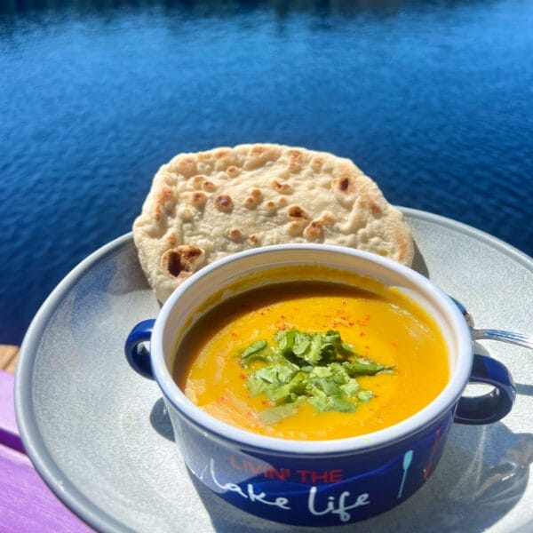 yellow split pea soup in bowl with flatbread on dock